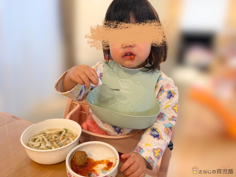 レバー入りミートボールのトマト煮を食べる娘