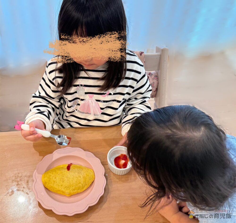 オムライスにケチャップをかける娘