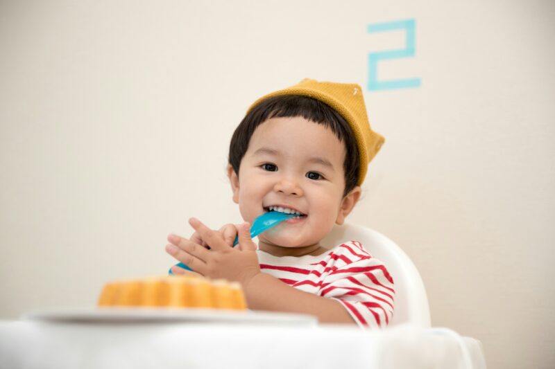 2歳時ぐらいの男の子が、楽しそうに食事している