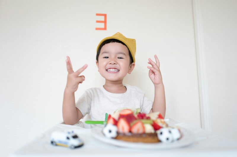 幼児が指で3を表している。
壁にも数字の3が書かれている