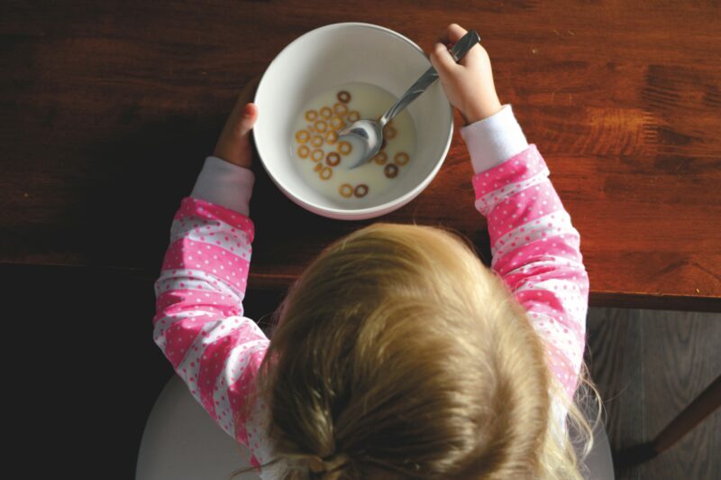 赤ちゃんがスプーンを使って離乳食を食べている様子