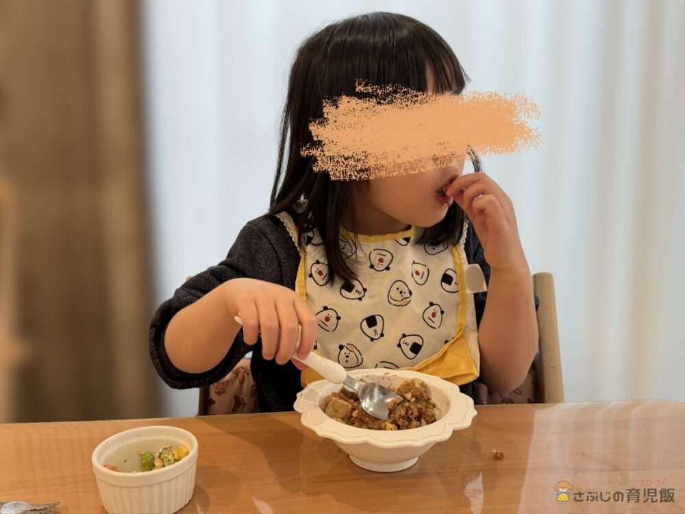 長女がツクリオの麻婆豆腐と副菜を食べている様子（顔加工済み）
